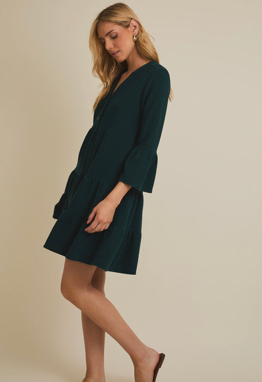 Woman wearing a dark green dress against a beige background