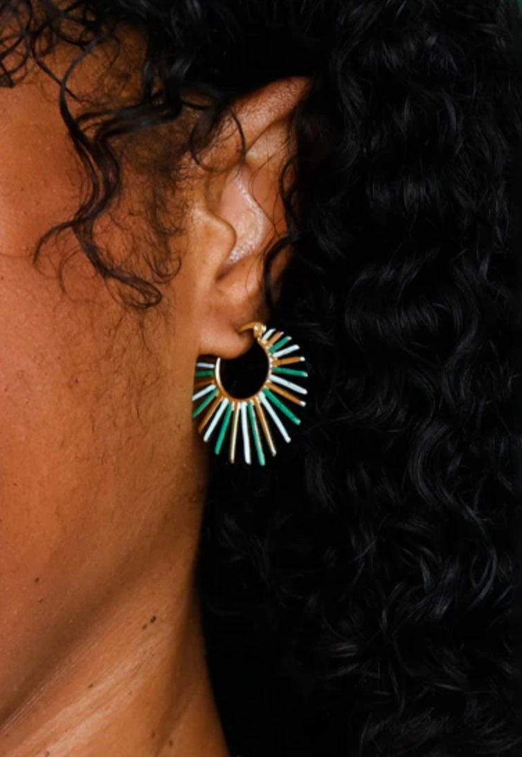 Close-up of an ear wearing a large, colorful hoop earring with dark hair.