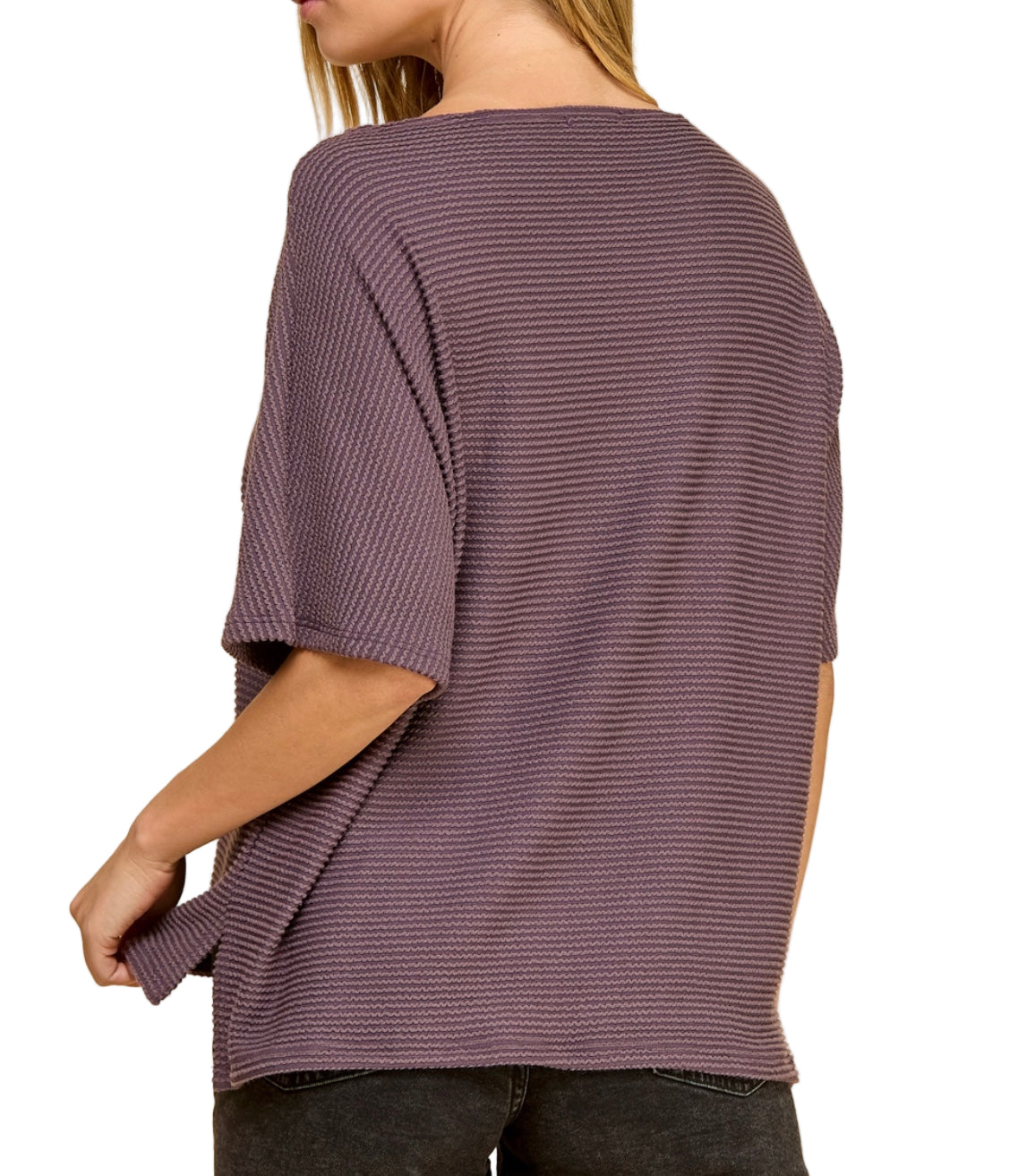 Person wearing a loose-fitting purple sweater on a white background