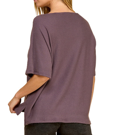Person wearing a loose-fitting purple sweater on a white background