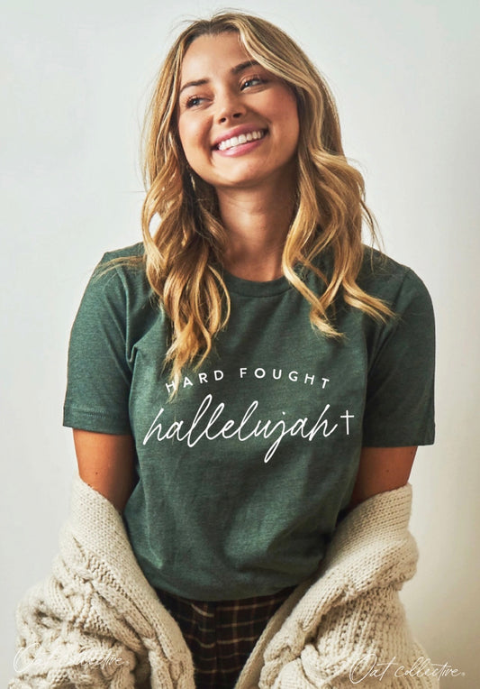 Woman wearing a green t-shirt with text, smiling against a plain background