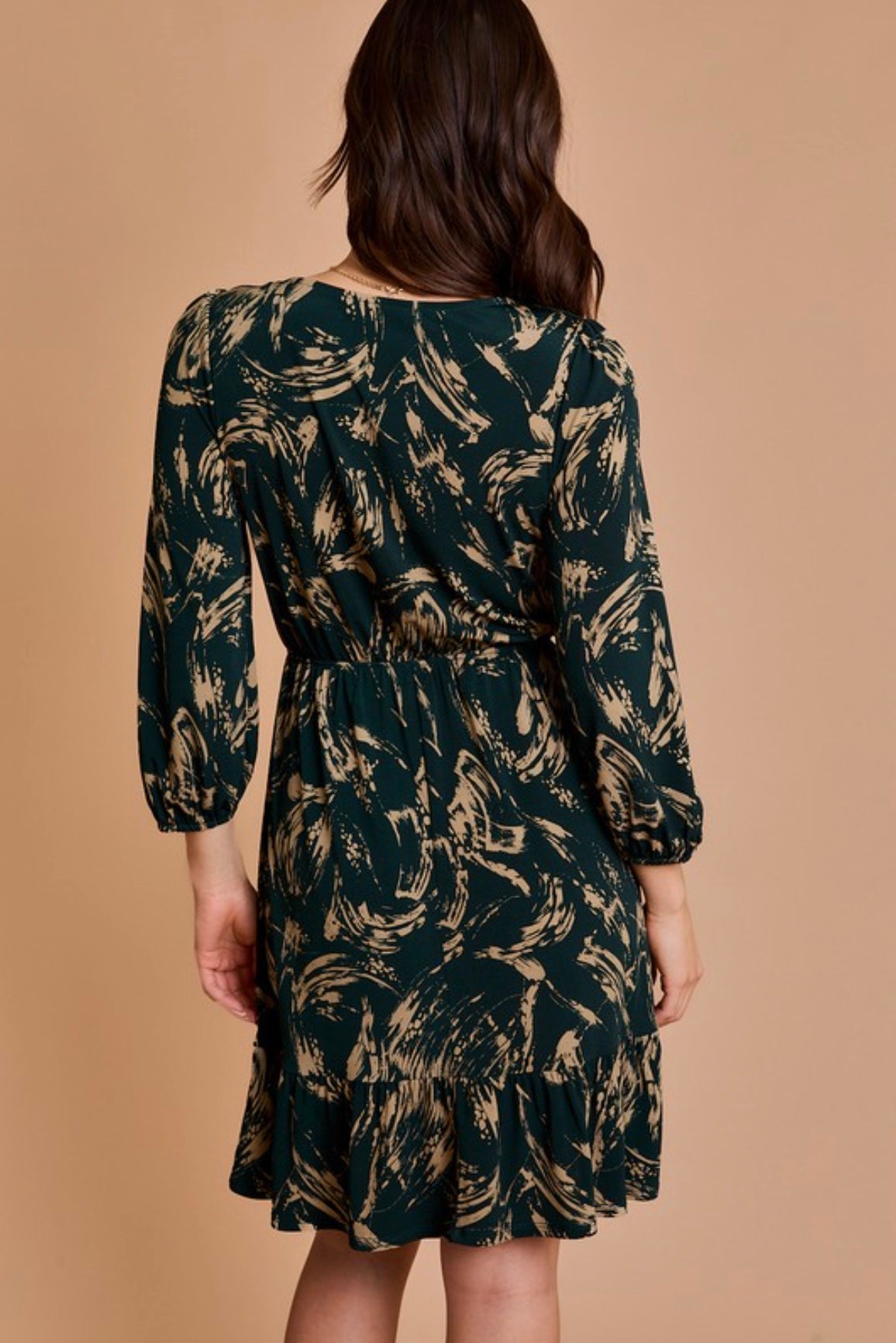 Woman wearing a patterned dress against a beige background