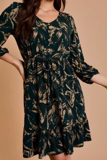 Woman wearing a dark green dress with a leaf pattern on a beige background