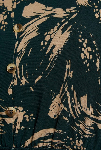 Close-up of a dark fabric with beige abstract patterns and buttons.